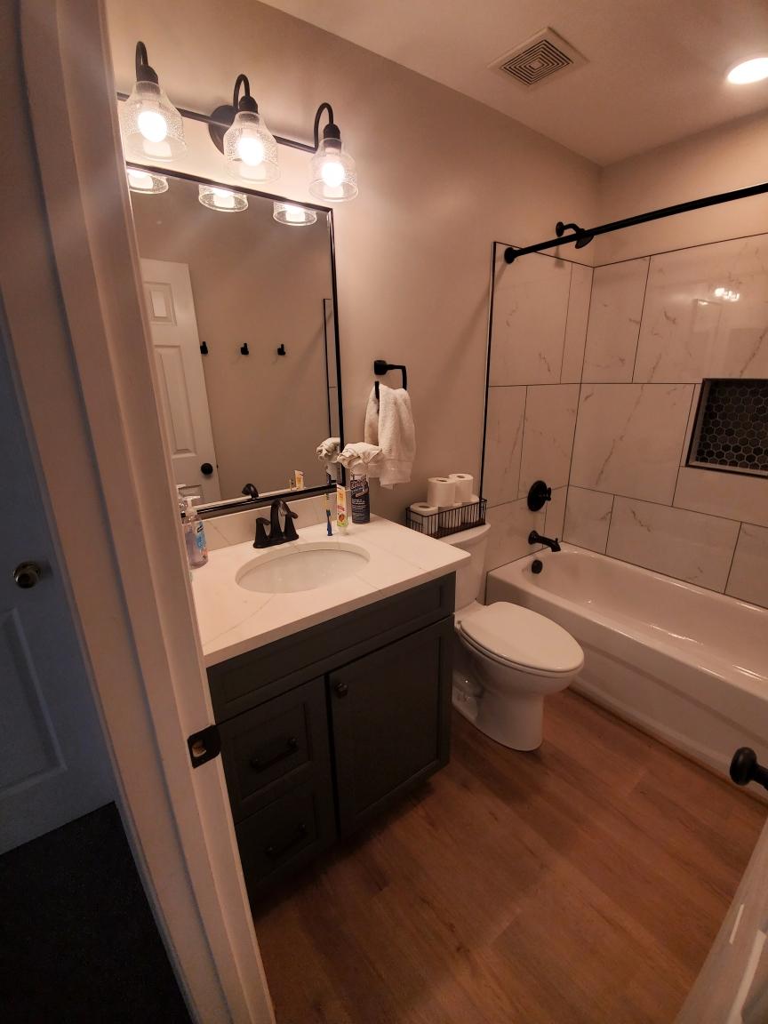 Bathroom vanity with black mirror and vintage sconce - Bradie's Custom Construction, Fredericksburg VA