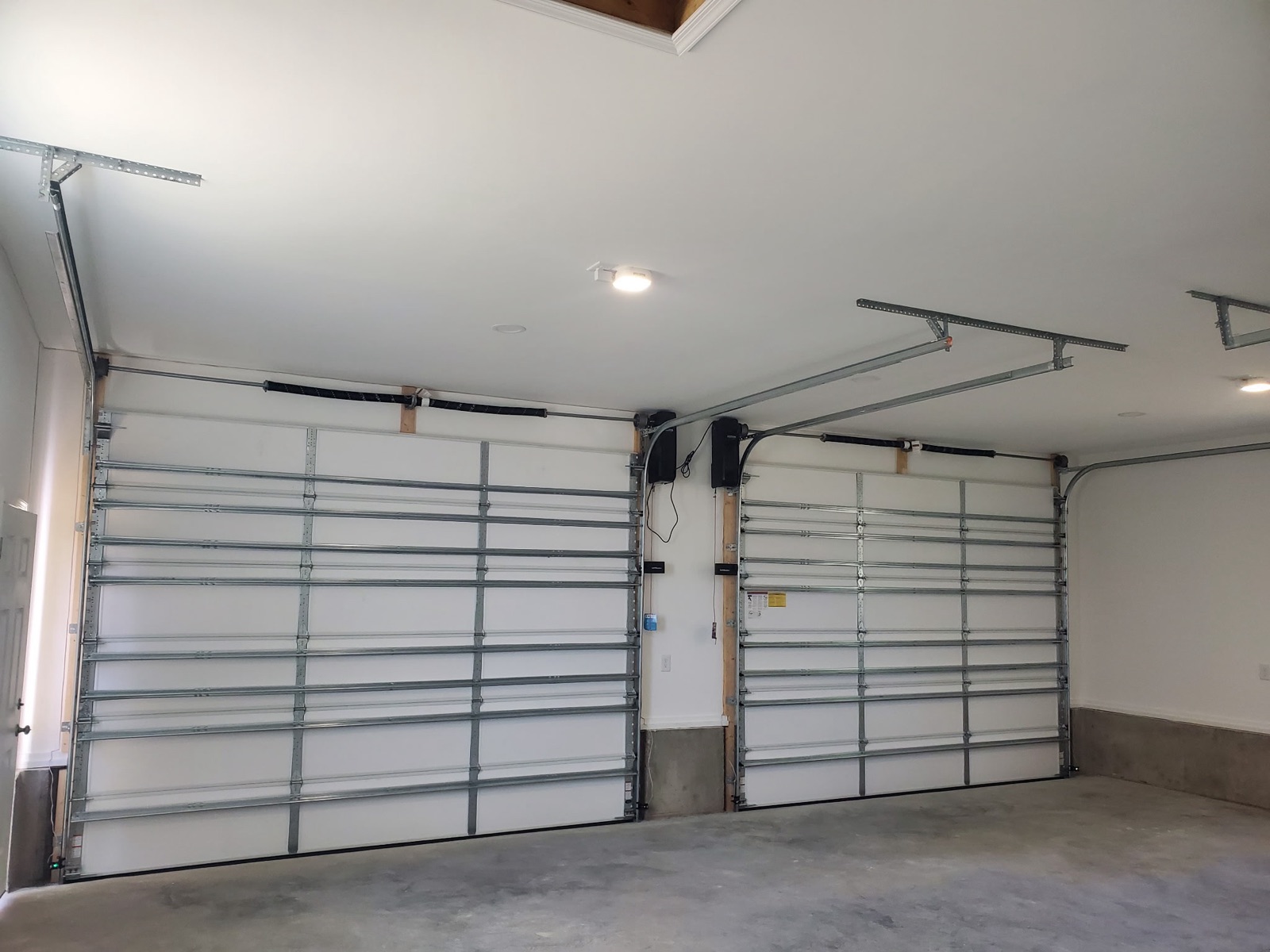 Finished garage interior with two wall-mount door openers - Bradie's Custom Construction, Fredericksburg VA