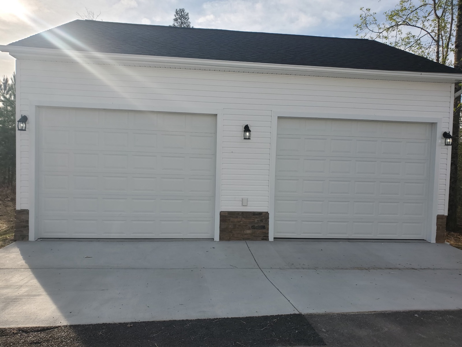 White two-car garage with stone skirt and concrete apron - Bradie's Custom Construction, Fredericksburg VA